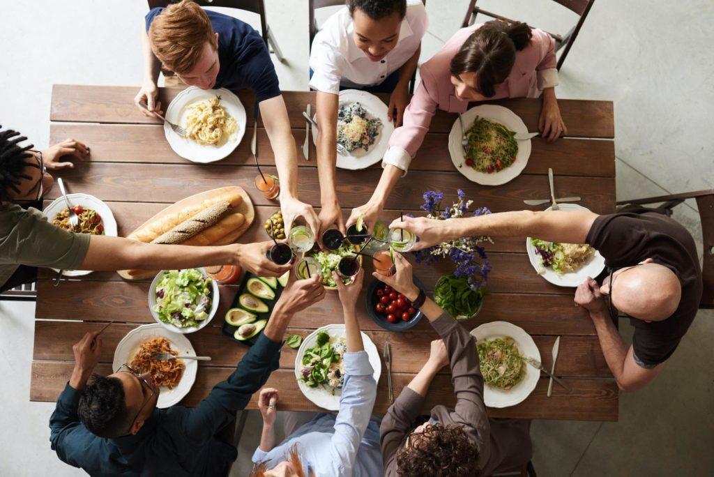Group of people enjoying a meal at a wooden table